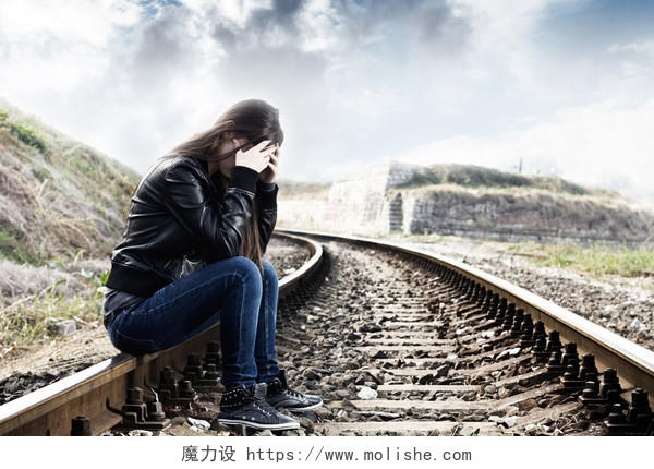 用手在她脸上坐在铁路上的孤独少女女人孤独无奈后悔